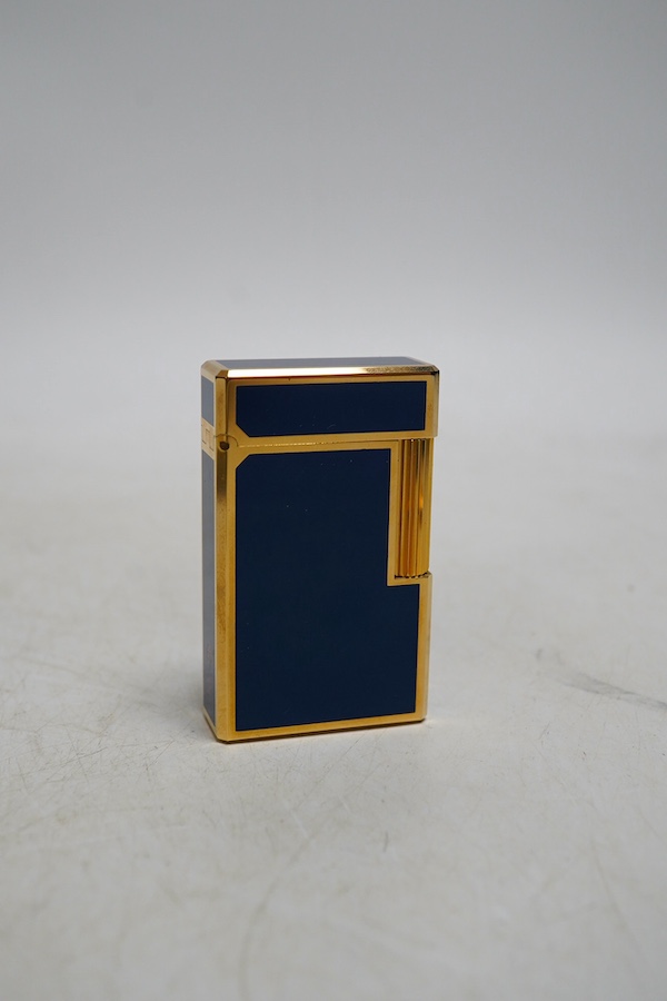 A Dupont gilt metal and blue enamel cigarette lighter with Japanese characters to the side, boxed with papers and a Piaget Montres Watches folding knife, cased. Condition - good